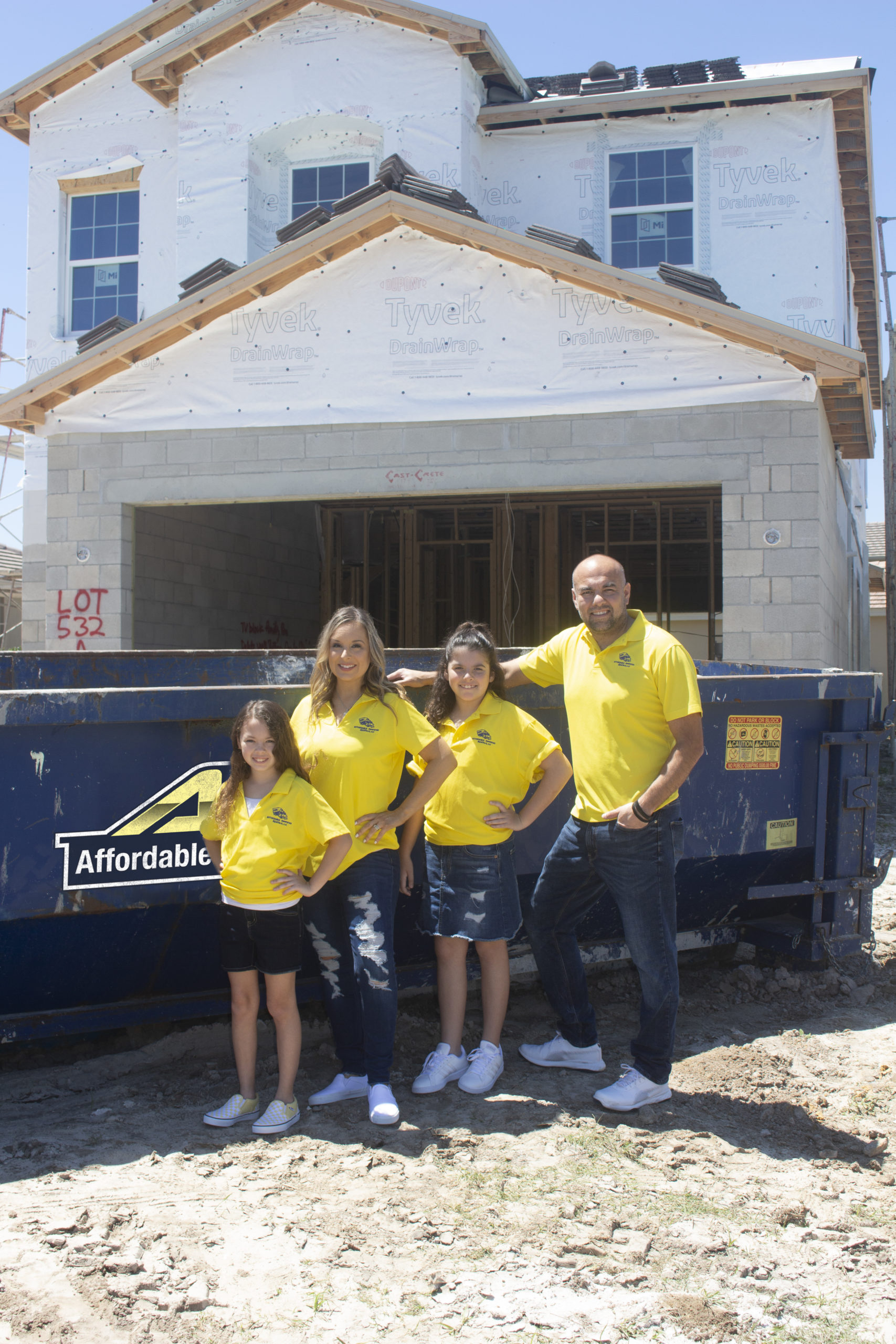 affordable-dumpster-rental-standing-family